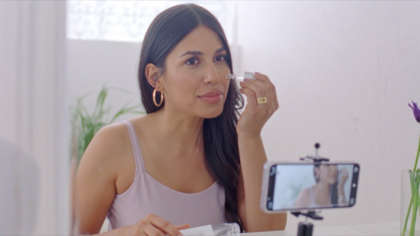 Creator applying the serum in her morning routine, with her phone filming her from a tripod